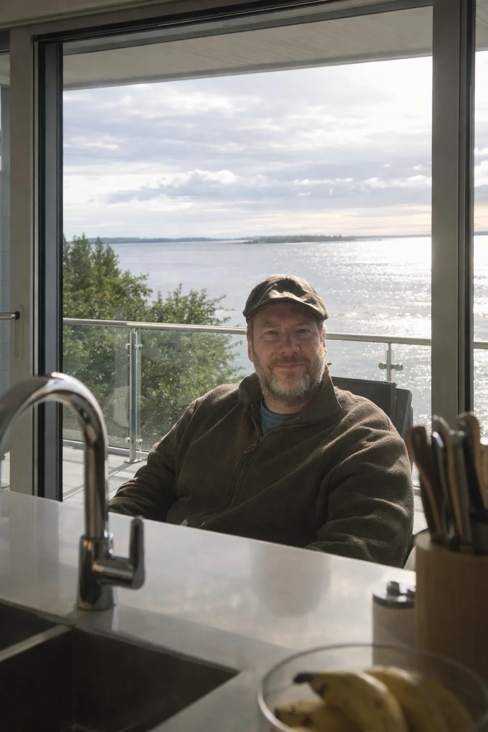 Erik Stenman seated by a window overlooking the sea